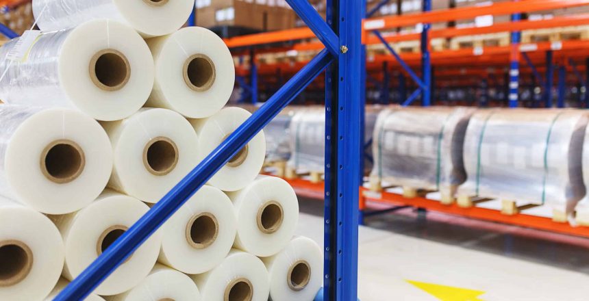 system of address storage of products, materials and goods in a warehouse. Rolls of polyethylene film in stock. Modern warehouse and storage systems.